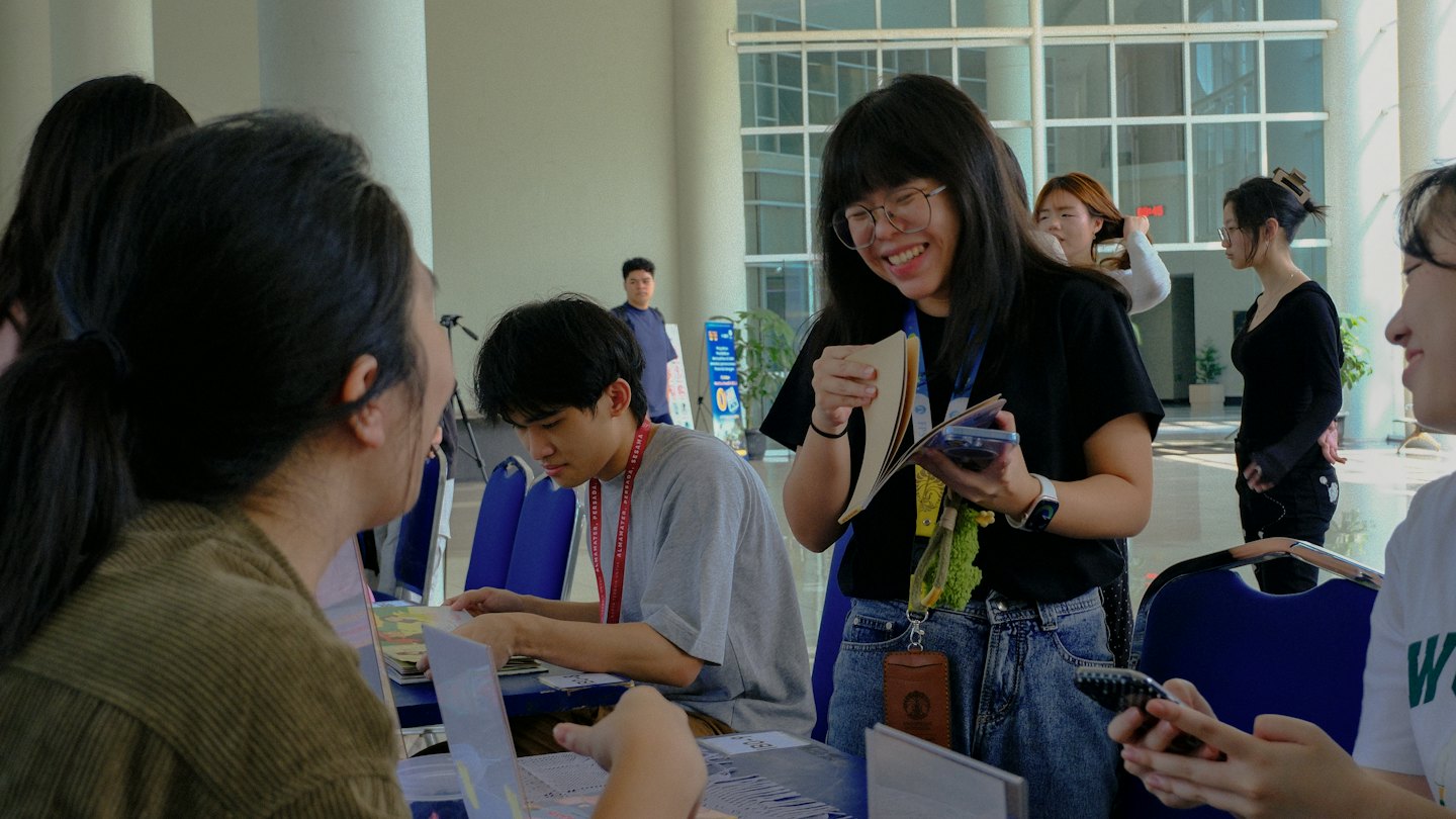 People interact at a registration desk in a modern building.
