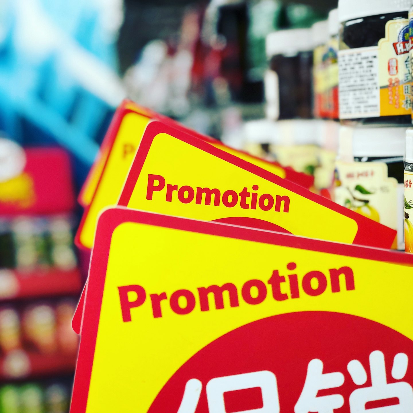 Yellow and red promotion signs in a store aisle.